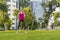 Young sportswoman performing exercises on the grass in a city