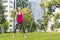 Young sportswoman performing exercises on the grass in a city