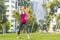 Young sportswoman performing exercises on the grass in a city