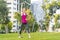 Young sportswoman performing exercises on the grass in a city