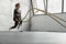 Young sportswoman with prosthesis working out with battle ropes