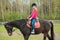 Young sportswoman riding horse in equestrian show jumps competition. Teenage girl ride a horse