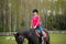 Young sportswoman riding horse in equestrian show jumps competition. Teenage girl ride a horse