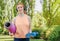 Young sportswoman in sportswear is holding a bottle of water and a yoga mat