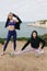 young sportswomen in stylish sportswear stretching on cliff Etretat