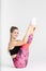 Young sportwoman stretching muscles on white background