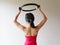 Young sporty attractive woman doing pilates toning exercise for arms and shoulders with ring, fitness with pilates magic circle