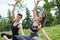 Young sporty couple stretching arms sitting on a mat in a park