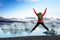 Young sporty girl with backpack admires beautiful view of the ice lake and mountains. Ice lagoon in Iceland