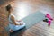 Young and sporty girl in meditating in home interior. Fit and slender blond woman goes in for sports and fitness.