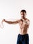 Young sporty man with a beard on a white background with gymnastic elastic bands in his hands. training with rubber