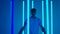 Young sporty man dancing hip hop against a background of bright blue neon lights. A silhouetted male dancer in casual
