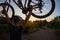 A young sporty man is holding a bicycle at sunset