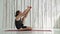 Young sporty man practicing yoga in fitness studio - heron pose, krounchasana