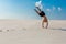 Young sporty man want doing acrobatic exercises on the sand near river