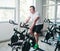 Young sporty man in white t-shirt and shorts is exercising bike at spinning class