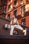 Young sporty teenager girl on roof of high-rise apartment building on brick wall background