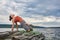 Young sporty woman doing different variants of yoga position on a rocky rivershore.