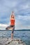 Young sporty woman doing different variants of yoga position on a rocky rivershore.