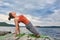 Young sporty woman doing different variants of yoga position on a rocky rivershore.