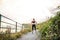 Young sporty woman runner in black activewear standing outside in nature, resting.