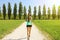 Young sporty woman running in park. Fitness girl jogging in park. Rear view of sporty girl running on pathway