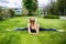 Young sporty woman sitting on grass in the park,gymnastic splits.