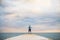 A young sporty woman standing on a pier by the ocean outside.