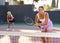 Young sporty woman tennis player dressed white t-shirt and shorts hitting ball with racket