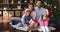 Young spouses with children posing by Xmas tree with gifts