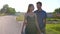 Young spouses walk along the street on a warm summer day.