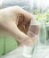 Young sprout in tube. Biotechnologies. Young green plant. Gardening. Growing plant. Lab worker holding tube. Blurred background