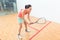 Young squash player holding the racket during game on a professional court