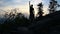 Young standing, celebrate on stone rock in czech landscape with trees at sunset