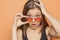 Young startled girl with orange sunglasses