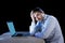 Young stressed businessman working on desk with computer laptop in frustration and depression