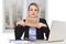 Young stressed businesswoman holding help sign overworked at office computer