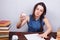 Young stressed student woman sitting at the table crumpling pape