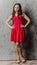 Young strict brunette in cocktail red dress