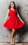 Young strict brunette in coctail red dress