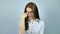 Young strict exacting female teacher wearing optical eyeglasses looking at the camera in studio on grey background