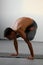 A young strong man doing yoga exercises - handstand or asana Urdhva Kukkutasana.