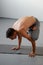 A young strong man doing yoga exercises - handstand or asana Urdhva Kukkutasana.