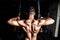 Young strong man workout training back muscles in the gym dark image