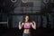 Young strong muscular fit girl with big muscles preparing for hard strength weight lifting or dead lift cross workout training wit