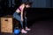 Young strong muscular fit girl with big muscles taking a break after hard strength kettlebell swing cross workout training in the