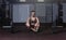 Young strong muscular fit girl with big muscles taking a break after hard strength weightlifting or dead lift cross workout