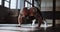 Young strong muscular shirtless Caucasian male athlete doing burpee exercises during functional workout in large gym.