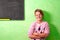 Young student in classroom next to blackboard