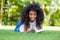 Young student girl reading a book in the school park - African p